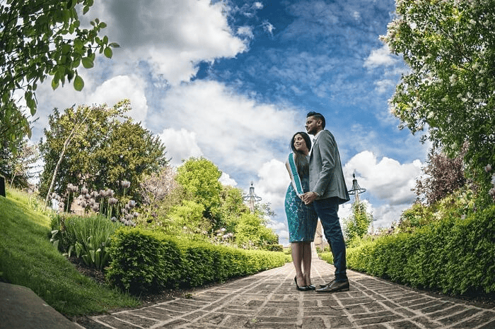 Pre wedding shoot of a couple in Rose Garden holding hands and aadmiring the beauty of nature. 