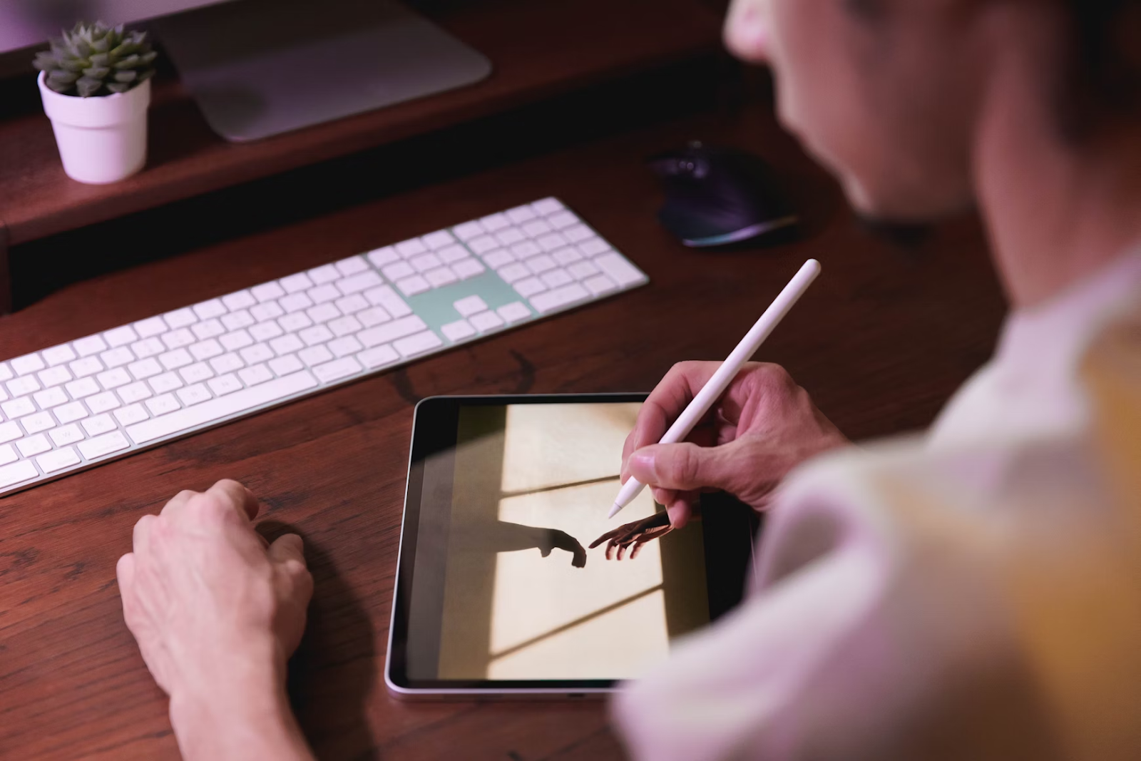 Person using an iPad with Apple Pencil to design or plan content, representing digital creativity and productivity
