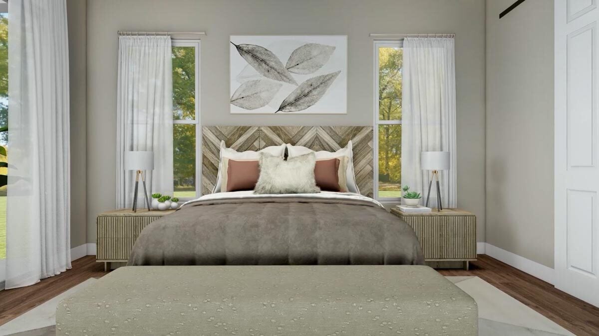 A custom chevron headboard along with leaves artwork adorn the primary bedroom.