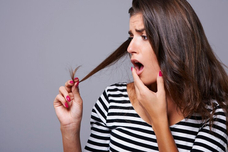 Woman frustrated holding Split ends of hair