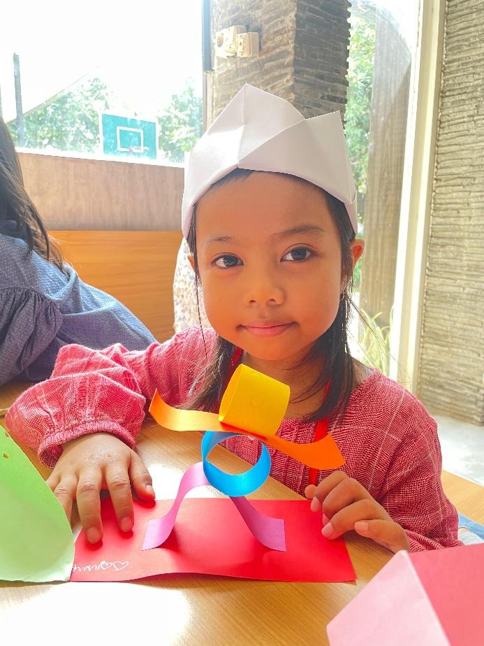 A child wearing a paper hat

Description automatically generated