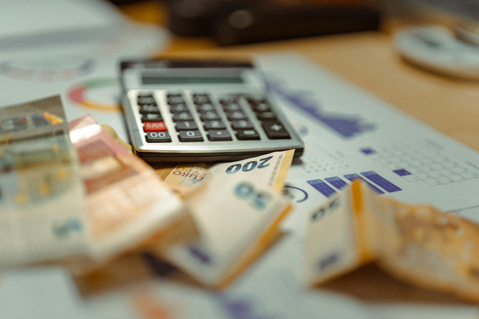 Euro banknotes and calculator on financial documents, focusing on business budget planning.