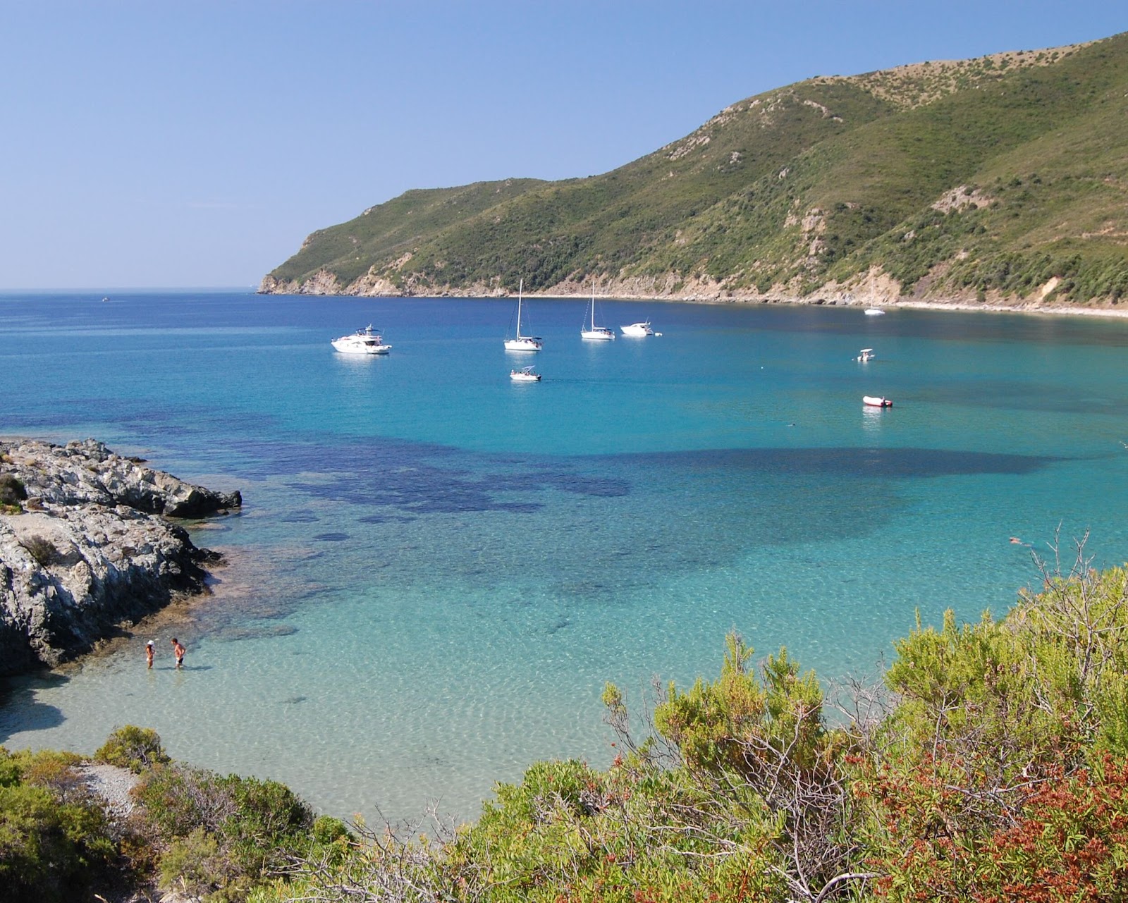 Water with boats and a mountain in the background.