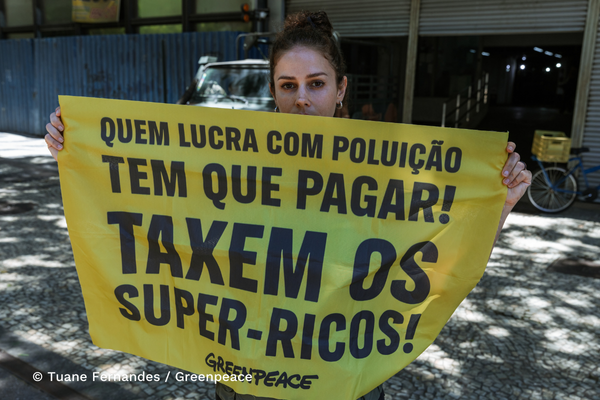 Imagem de ativista segurando cartaz na G20