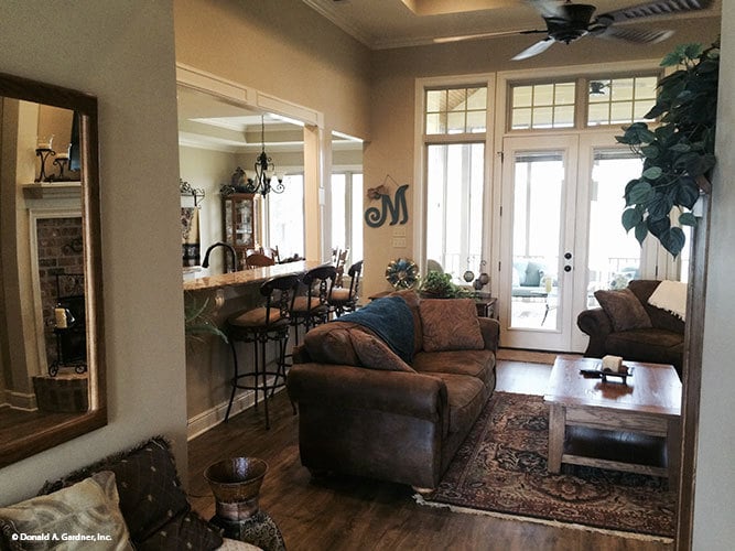 Living room with leather seats and a distressed coffee table over a tasseled area rug.