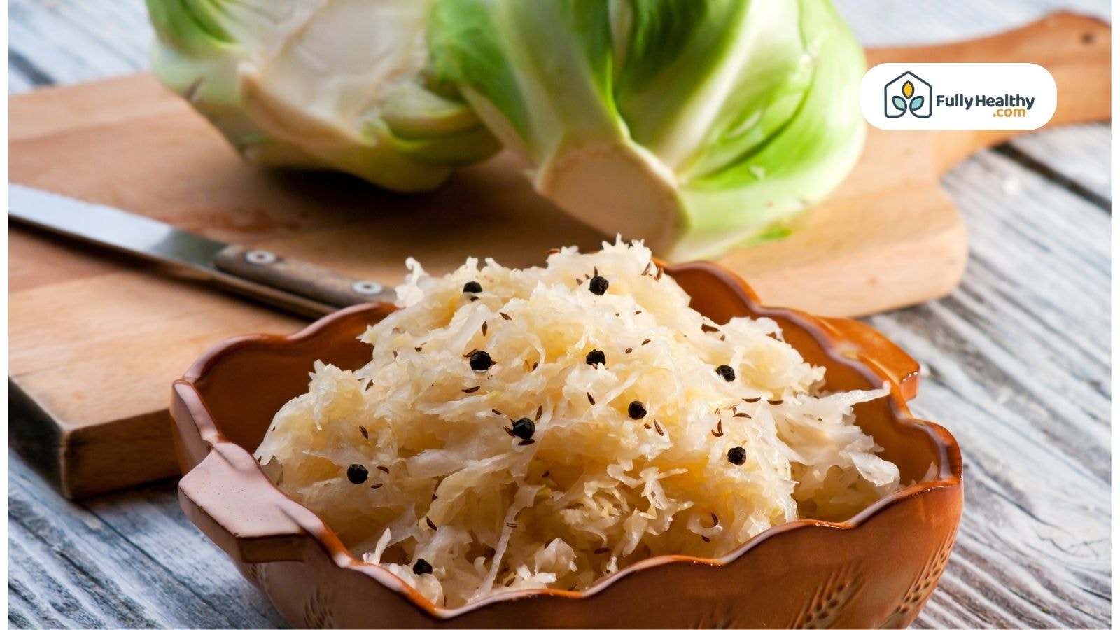Sauerkraut with peppercorns beside cabbage on wooden board