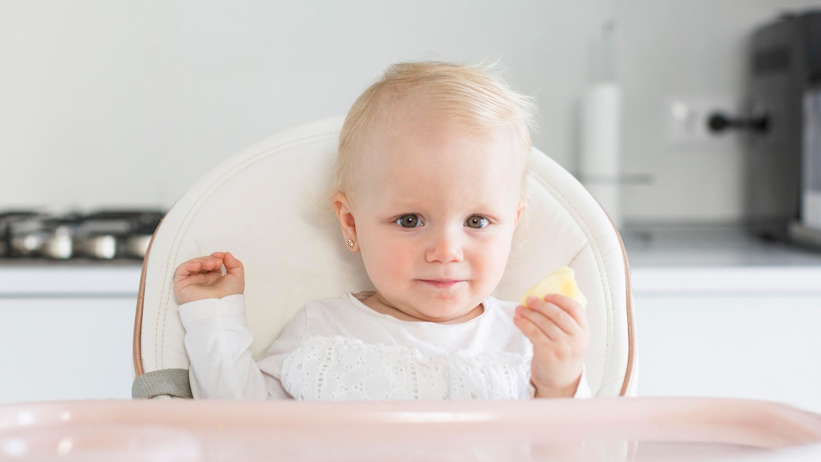 A little girl holding a slice of apple