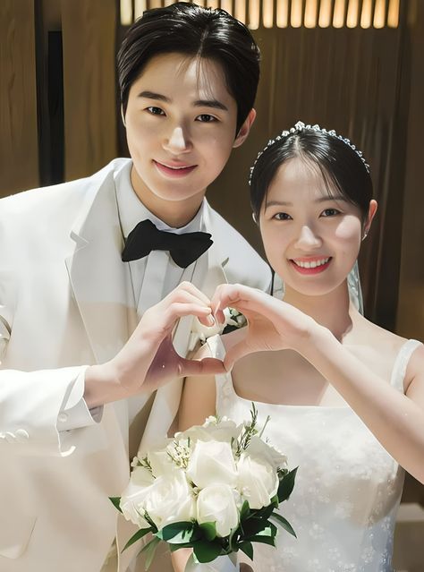 This contain Byeon Woo Seok and Kim Hye Yoon making a heart shape with their hands as they pose for the camera