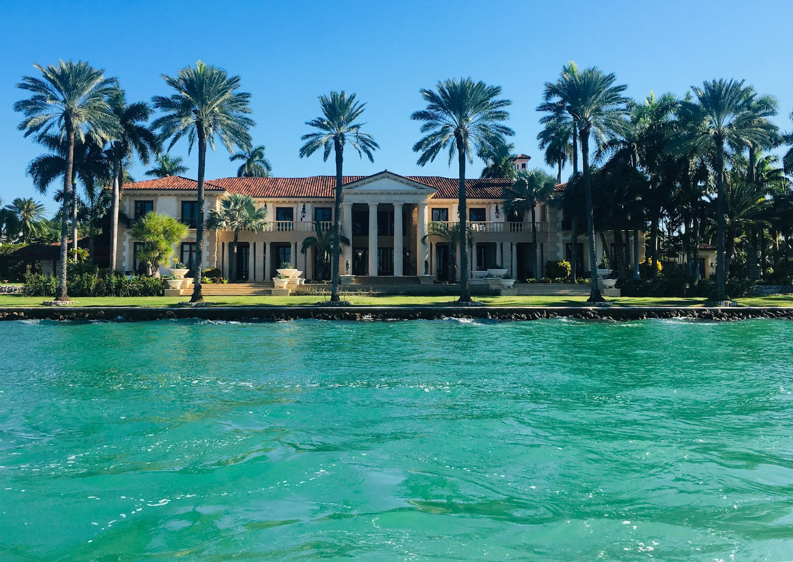 Florida mansion on a clear, sunny day with a bright blue sky and no clouds in sight.
