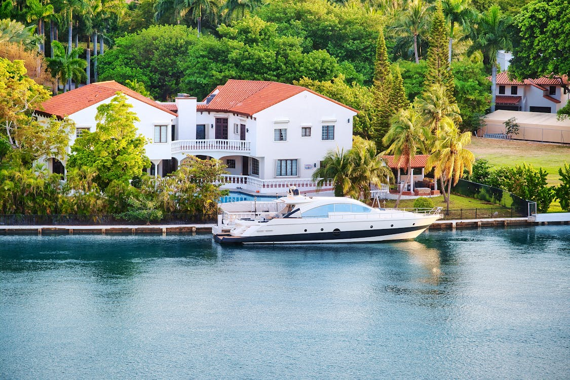 white house with brown roof near water