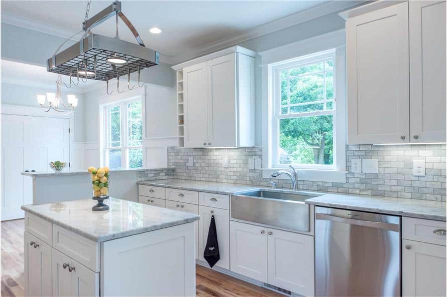 The kitchen includes a farmhouse sink and a white framed window that invites natural light in.