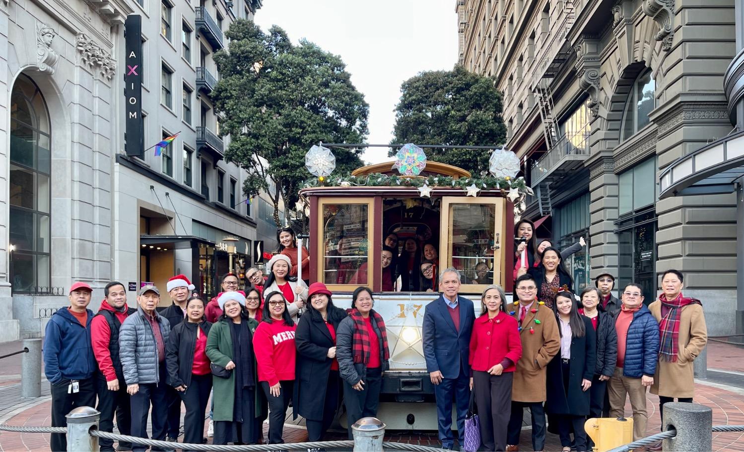 A group of people standing in front of a trolley

Description automatically generated