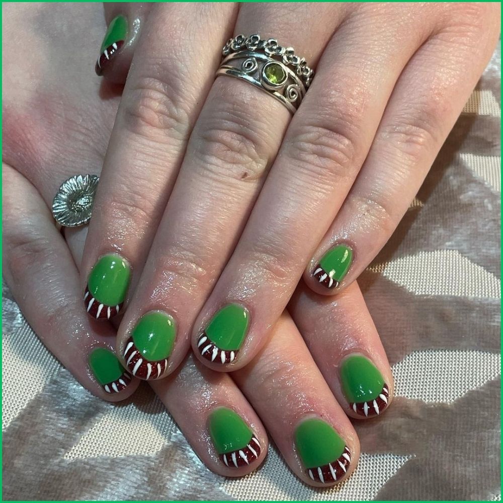 Close up of hands with Christmas Green Nails having  Candy Cane French Tips