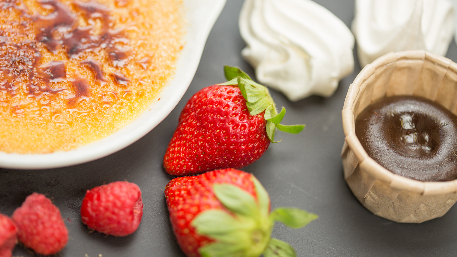 Gambar buah strawberry dengan kue coklat dan caramel di sampingnya/Sumber: Canva