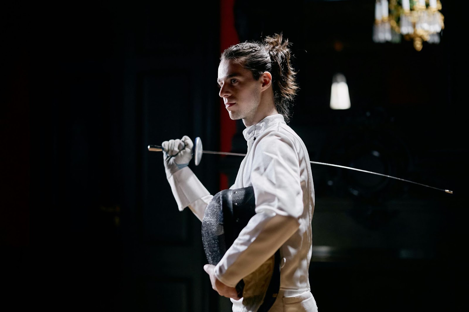 A martial arts student posing with his light sowrd on his right shoulder