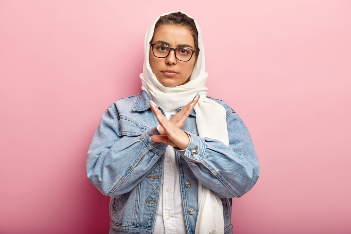 Wanita dengan baju denim dan kerudung putih.