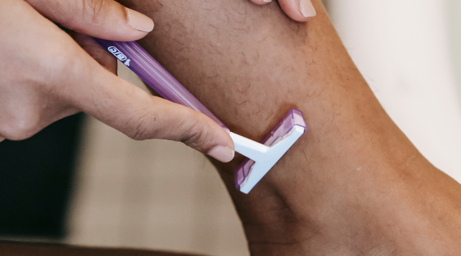 woman with hirsutism shaving her legs