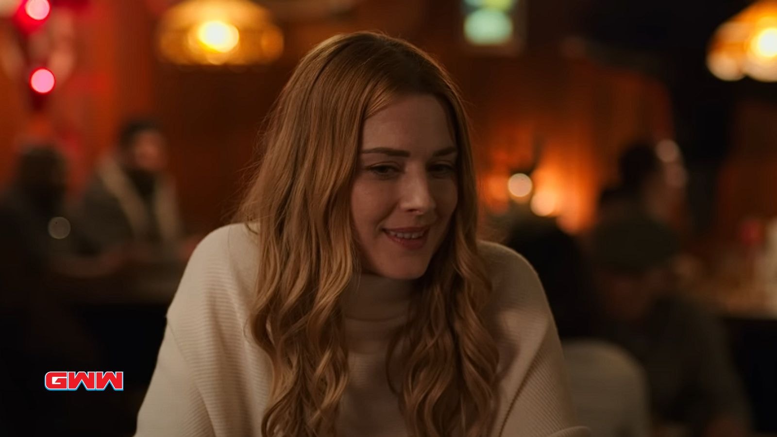 Alexandra Breckenridge as Mel Monroe smiling in a cozy restaurant setting