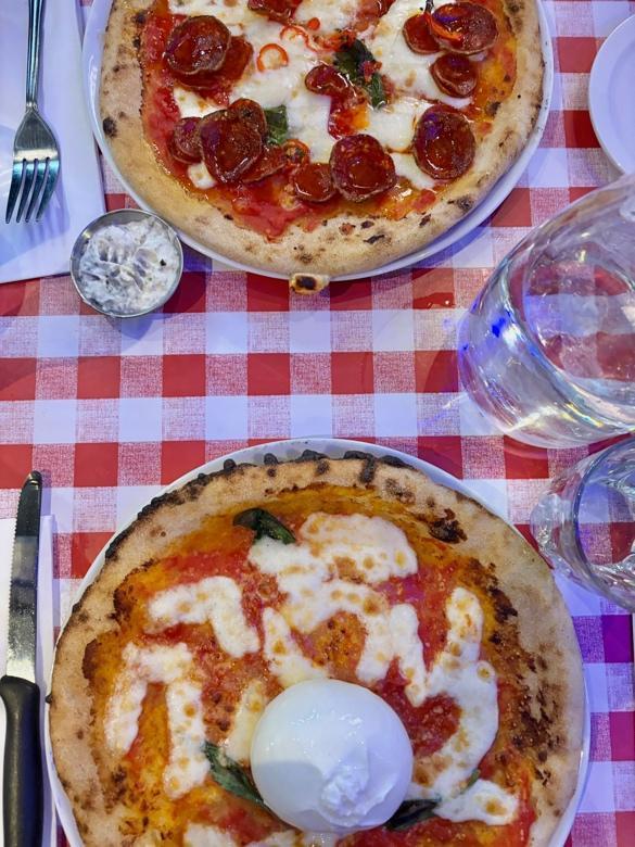 A two pizzas on a table

AI-generated content may be incorrect.