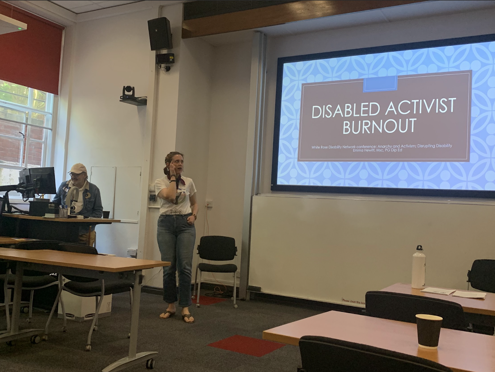 A person stood in front of a screen that reads: disabled activist burnout