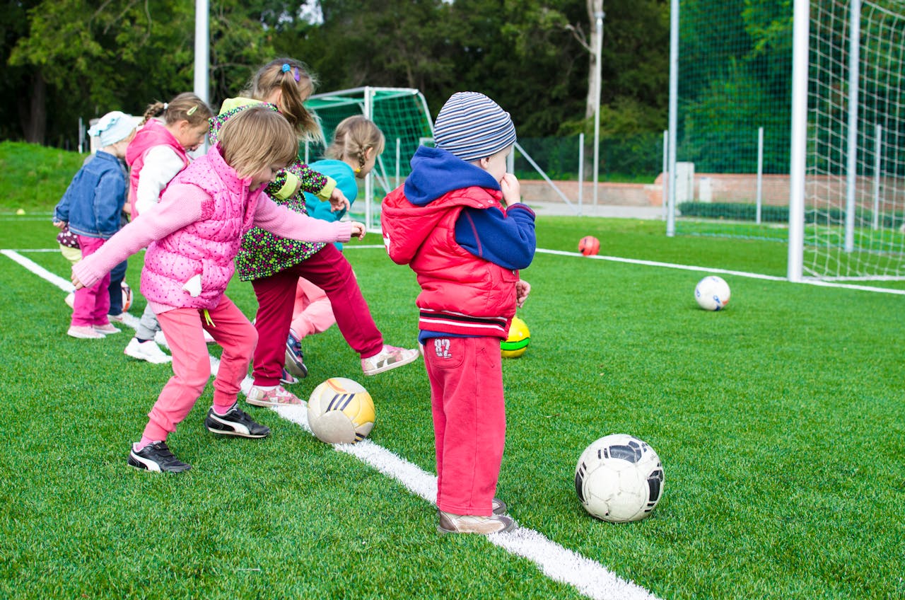 Children having fun playing soccer on turf.