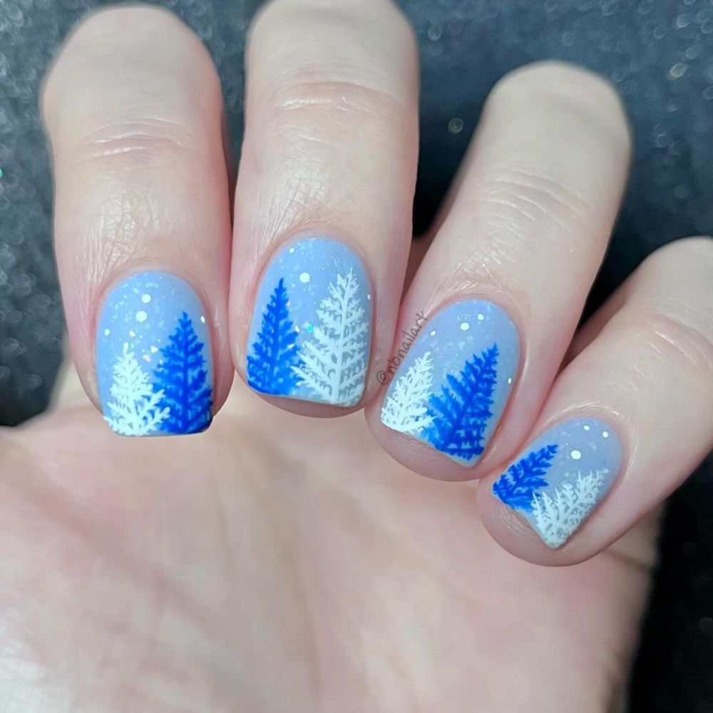 Close up of hands with blue winter nails having frosty designs