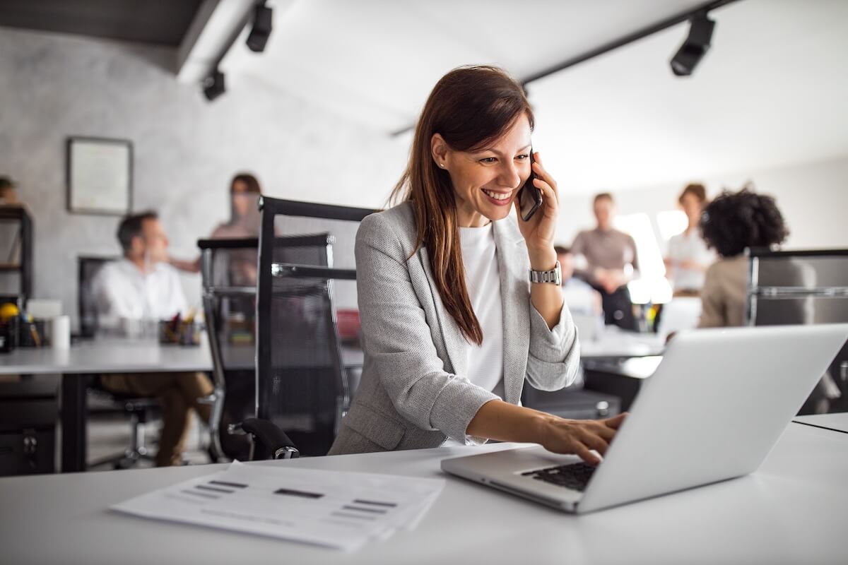 Leave request workflow: employee talking on the phone while using a laptop