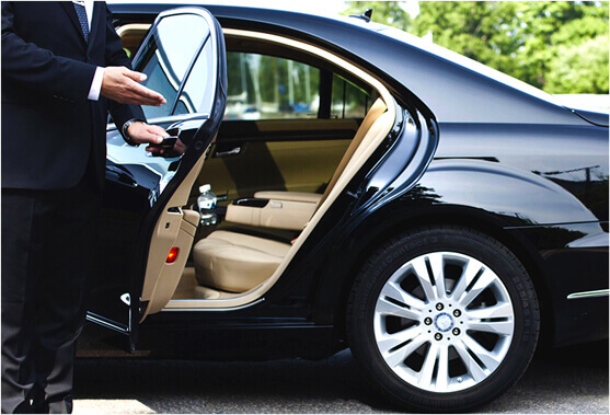 Luxury black car and chauffeur assisting