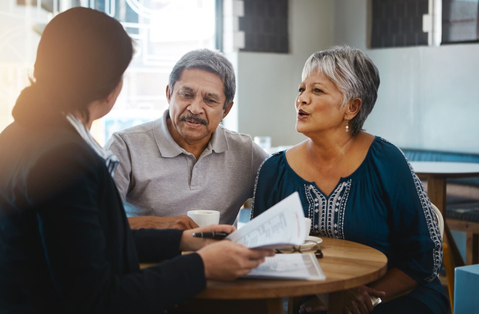 A relaxed senior couple discuss their finances with a financial advisor.