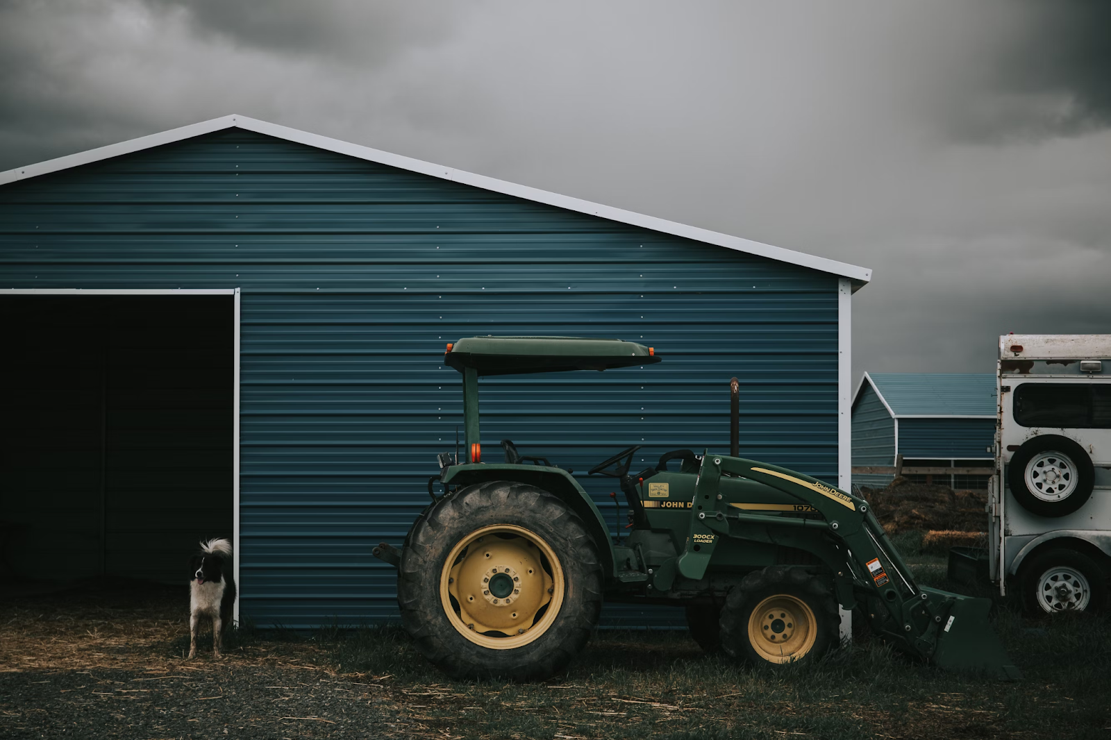 Green equipment storage shed with a tractor 