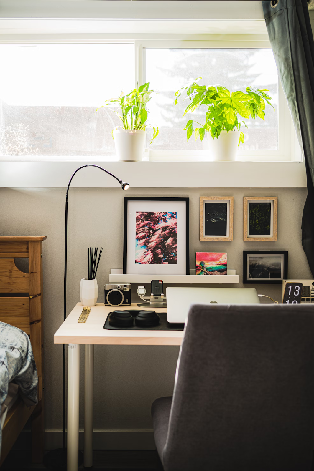 How AI helps with essay writing. A desk in a bedroom holds a closed laptop and multiple pieces of artwork. It’s a relaxing and positive space to start writing an essay.