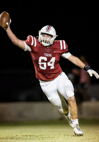 A football player in a red uniform with a football in his hand

Description automatically generated