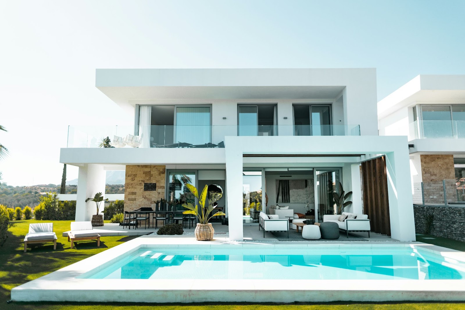 A inground pool behind a nice house from another angle.