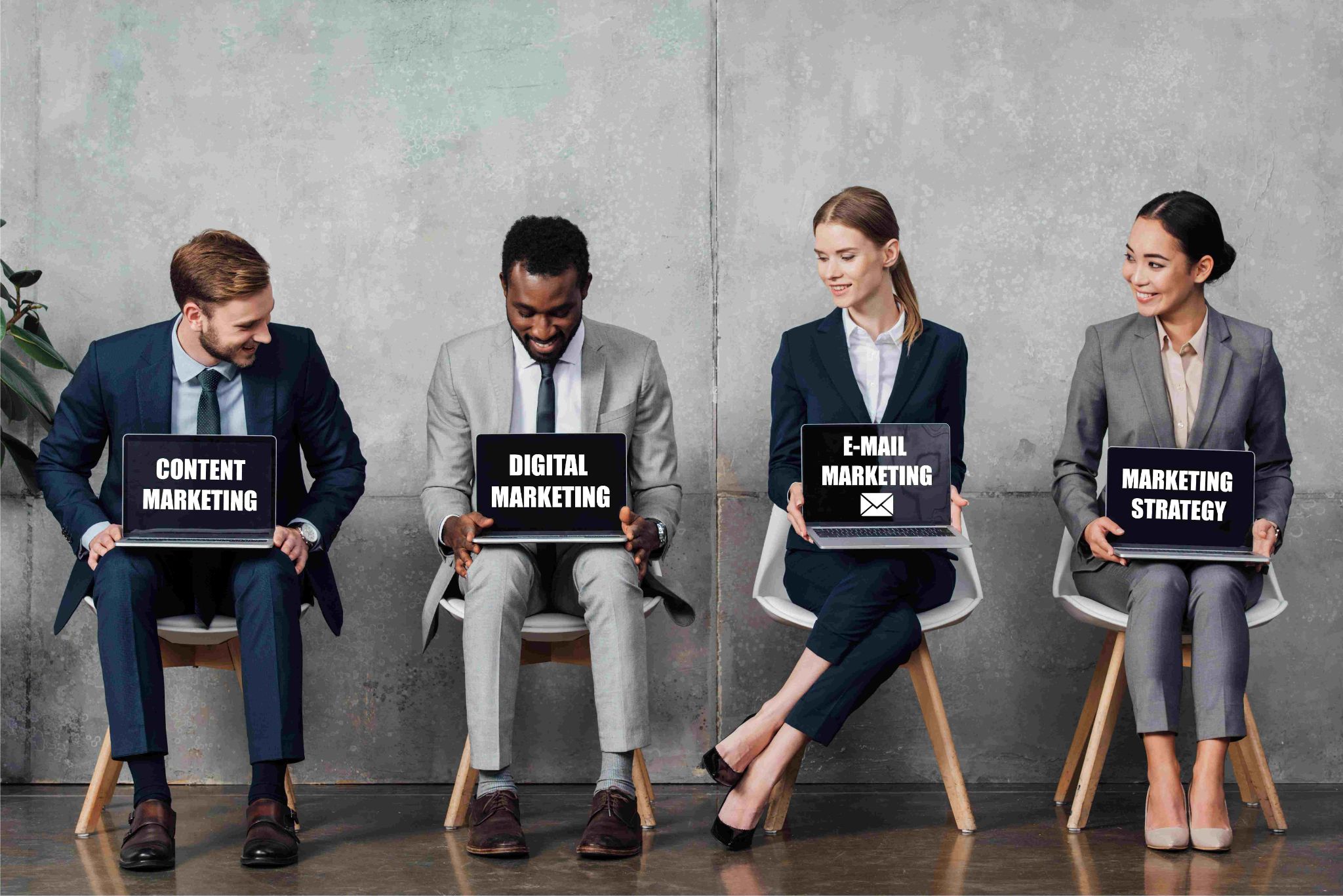 Four professionals holding laptops with marketing terms