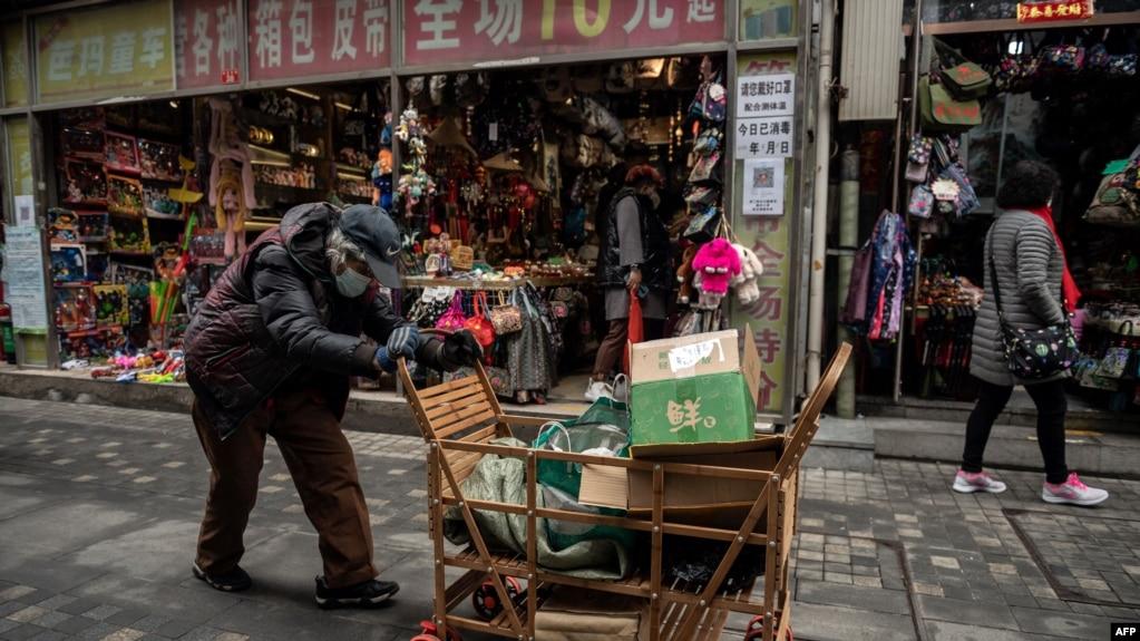 资料照:一名拾荒老人走过北京街头。(2021年3月5日)