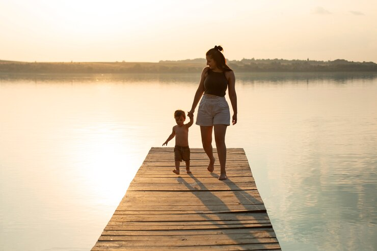 A mom spending time with kid on a pier at sunset