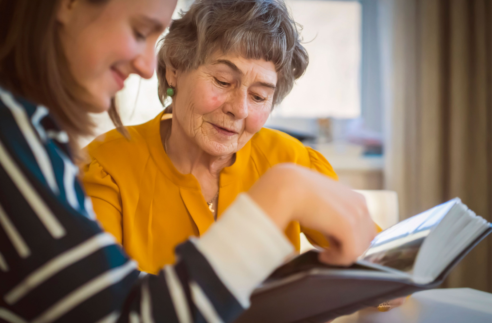 An adult child shows their senior parent with memory loss photos.