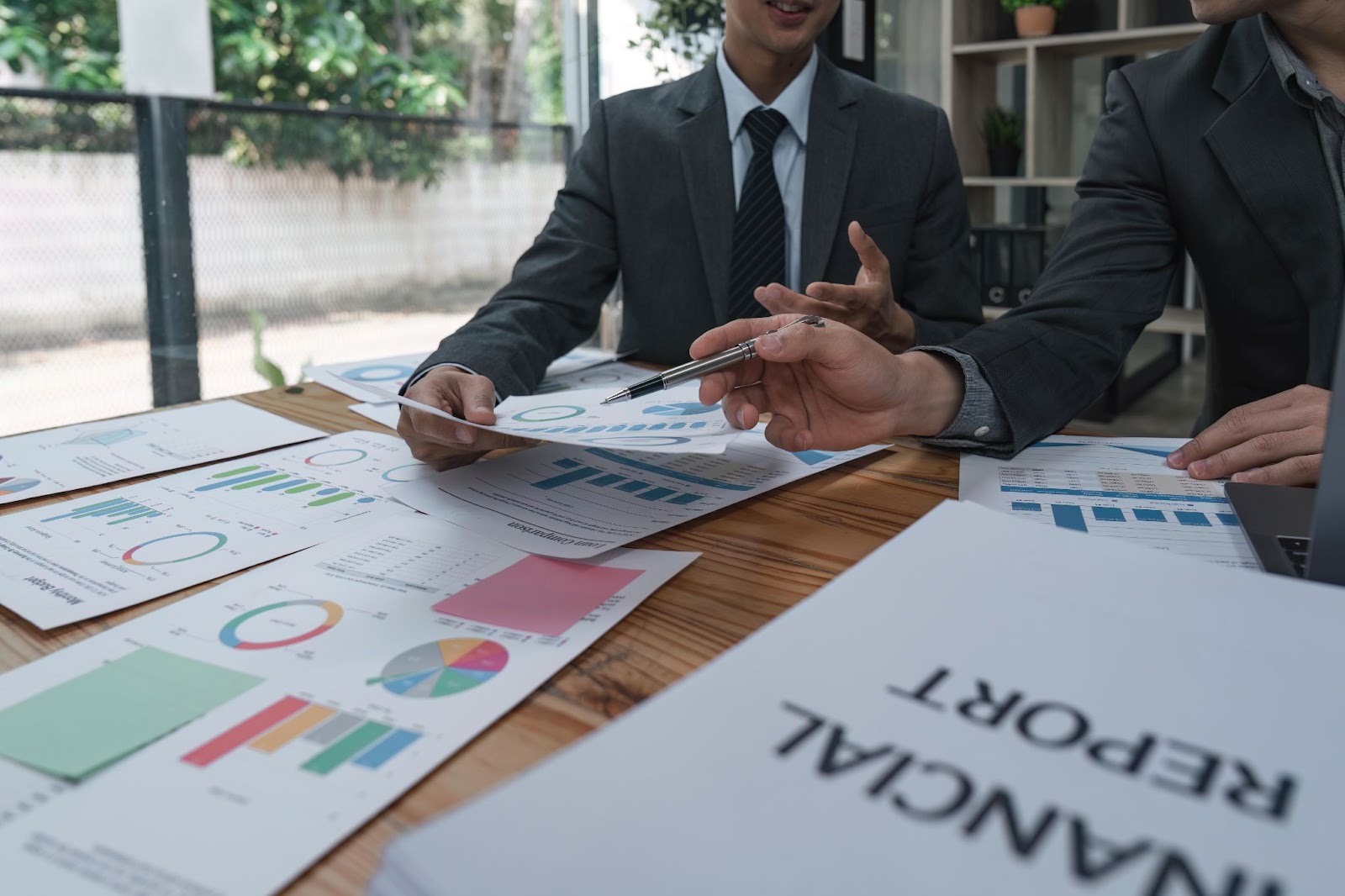 A cropped shot of two business professionals discussing compliance strategies for a new startup project, emphasizing teamwork in business risk management.