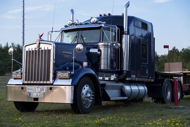 A bobtail truck (a truck without a trailer attached) sits in a lot, waiting to pick up a trailer.