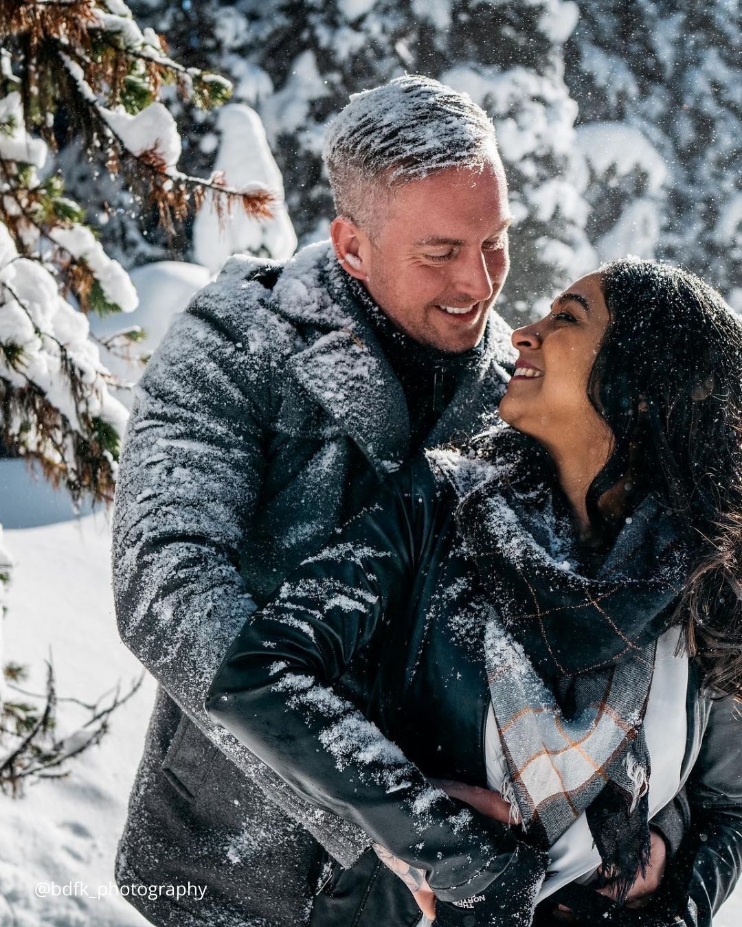 winter engagement photos frosen couple looking at each other