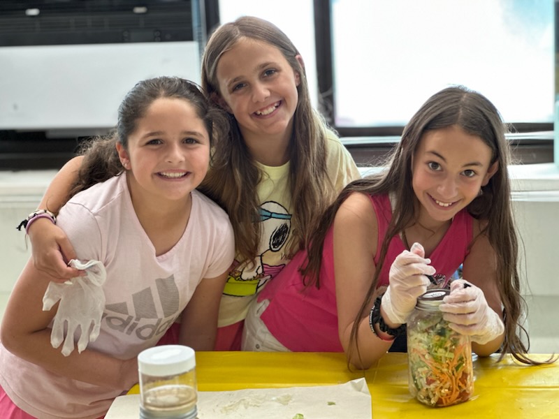 students smiling while prepping veggie jars