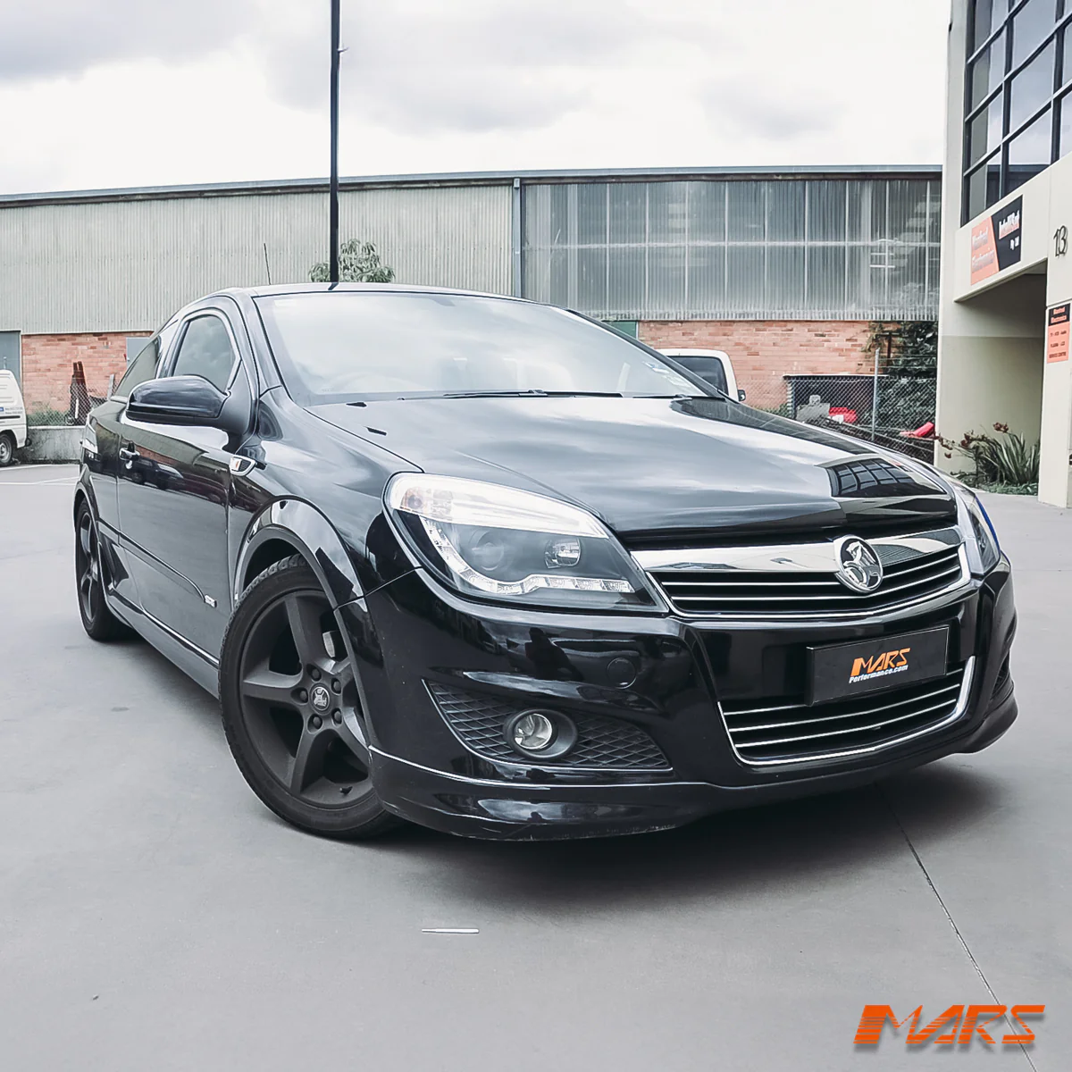 Black Holden Astra fitted with Mars Performance headlights, showcasing a stylish upgrade for better road visibility.