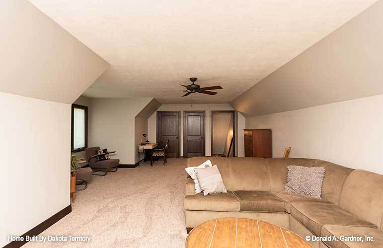 Bonus room with a vaulted ceiling, carpet flooring, and beige walls.