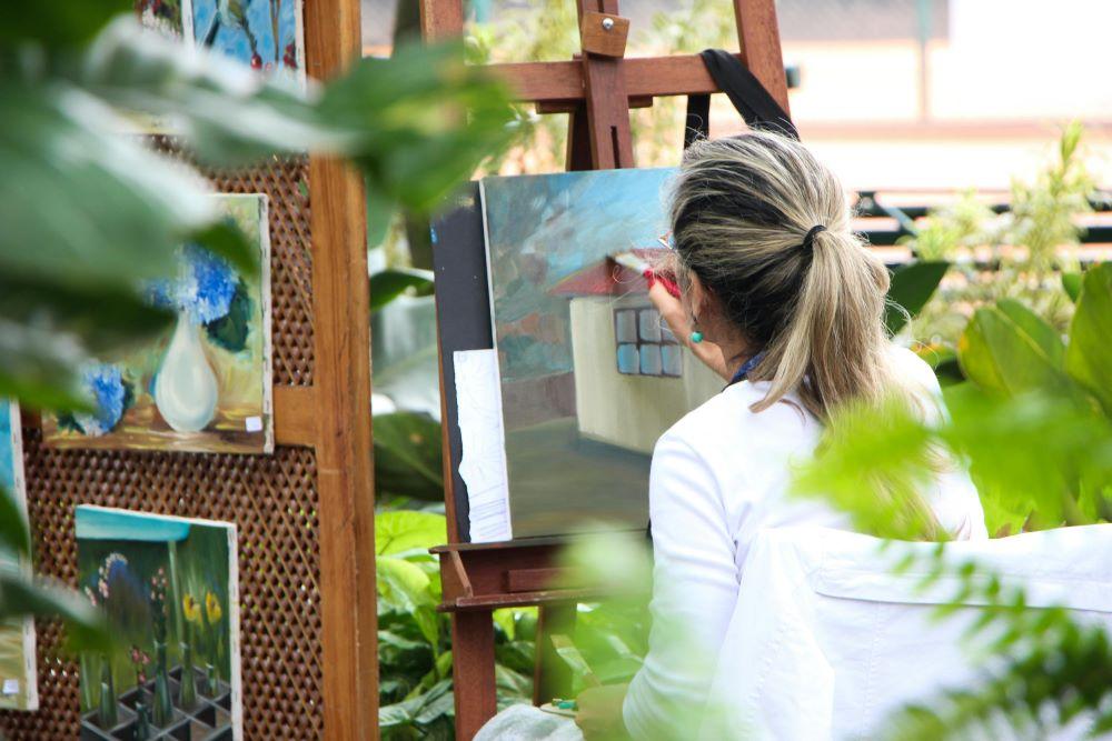 A woman painting in her garden