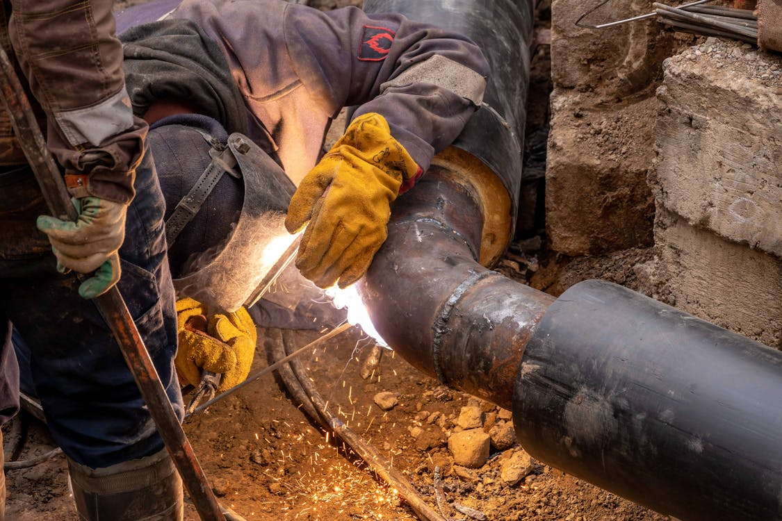 man sawing into a pipe