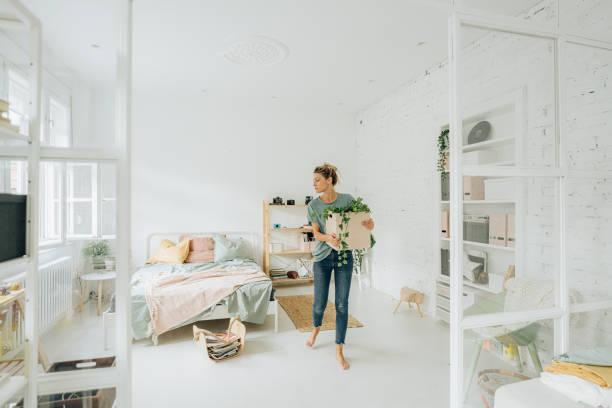 A person holding a box in a bedroom