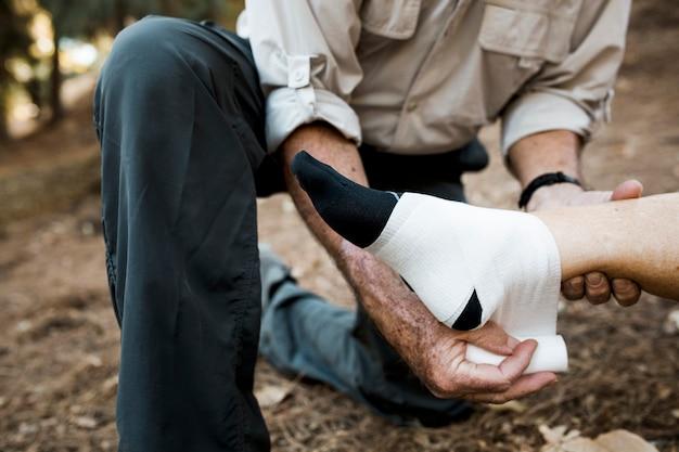 Elderly man bandaging his wife