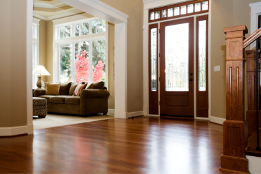 hardwood vs luxury vinyl flooring comparing interior upgrades foyer and living room area near stairs custom built michigan