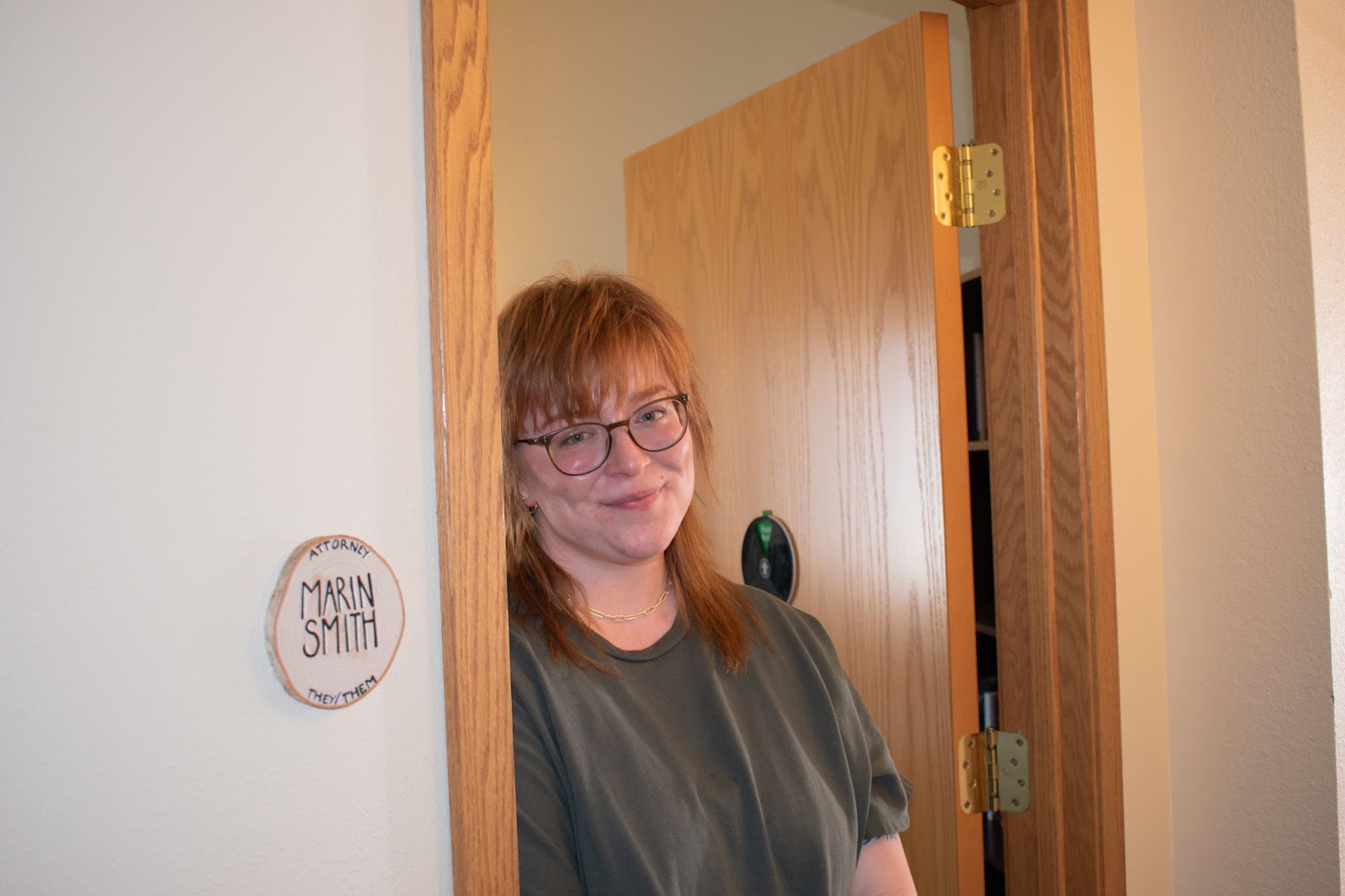 Women smiling standing by a door. 