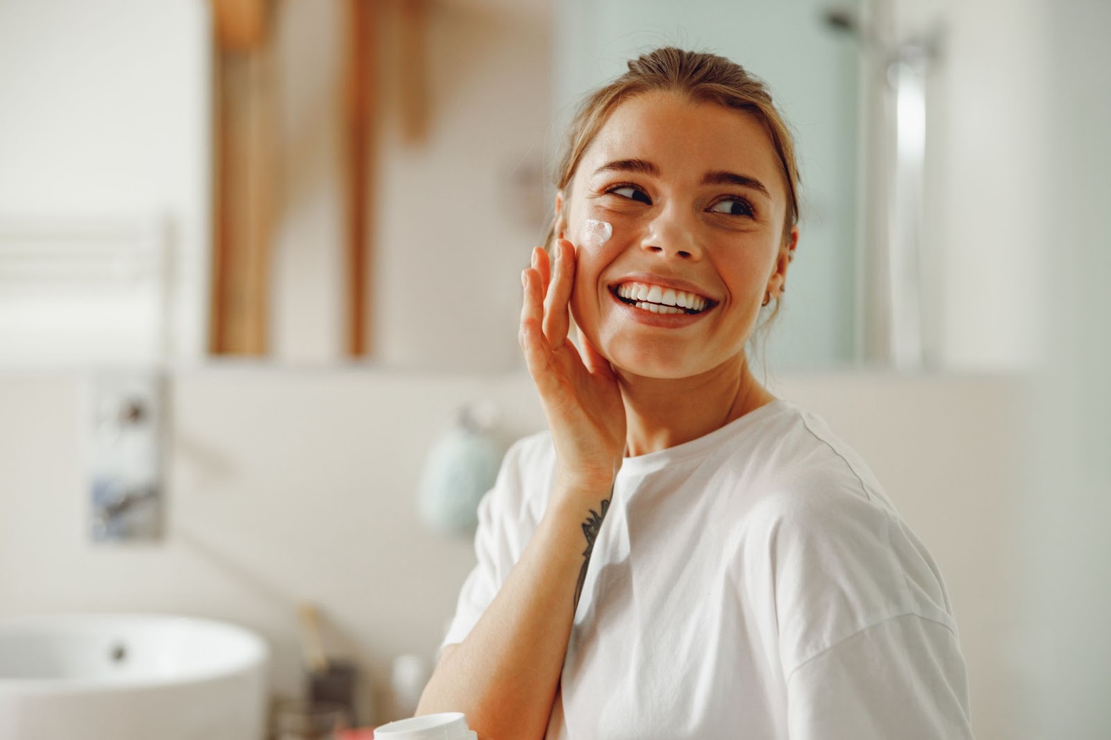 a girl putting lotion on her face